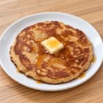 Fluffy keto cream cheese pancakes stacked on a plate, golden brown and ready to serve.