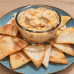 Keto Buffalo chicken dip with shredded chicken and melted cheese, served warm as a creamy appetizer.